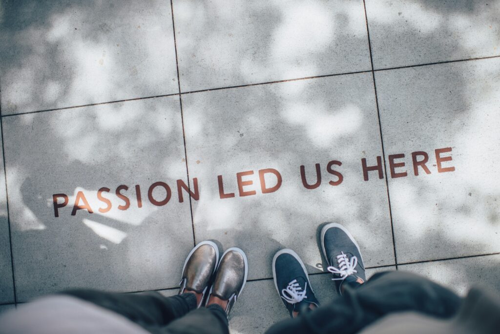 two people standing on grey pavers that say "passion led us here"