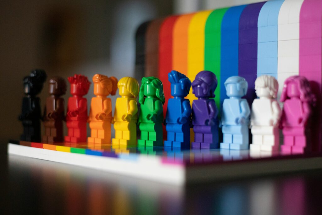 multi colored mini-fig lego blocks with a lego rainbow pride flag.